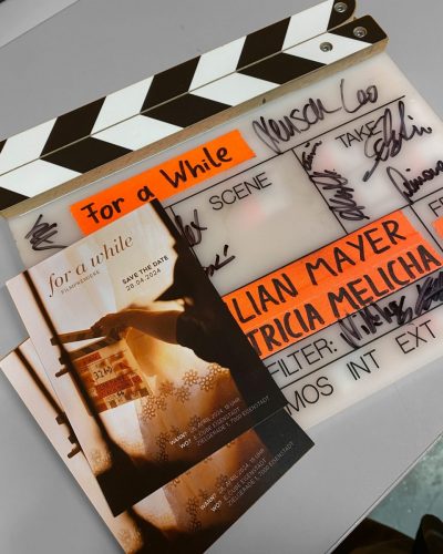 Flyers for the premiere of For A While on the film slate used during production
